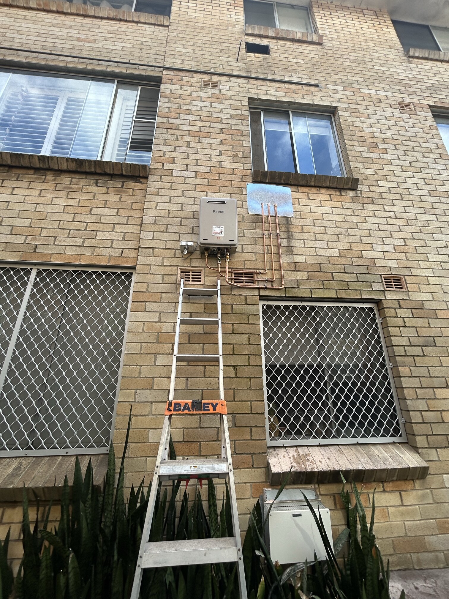Emergency Hot Water Repairs technician with a new hot water system in Sydney Cbd